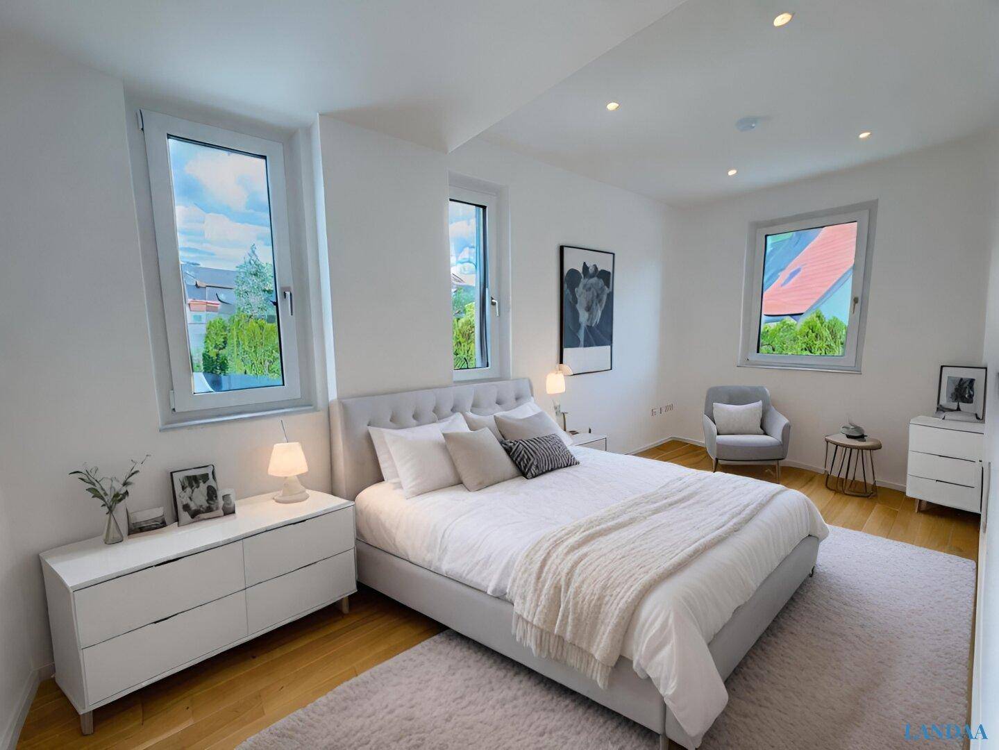 Helles Schlafzimmer mit großem Bett, Holzboden und mehreren Fenstern für viel Tageslicht.