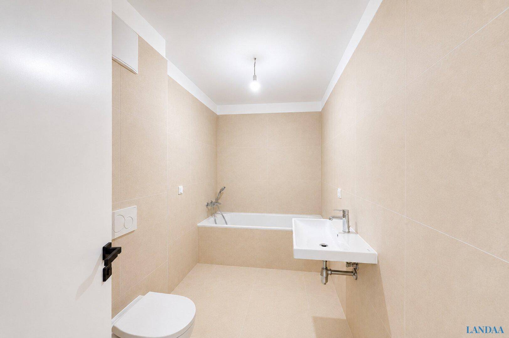 Modernes Badezimmer mit beigefarbenen Fliesen, Badewanne und wandhängendem WC.