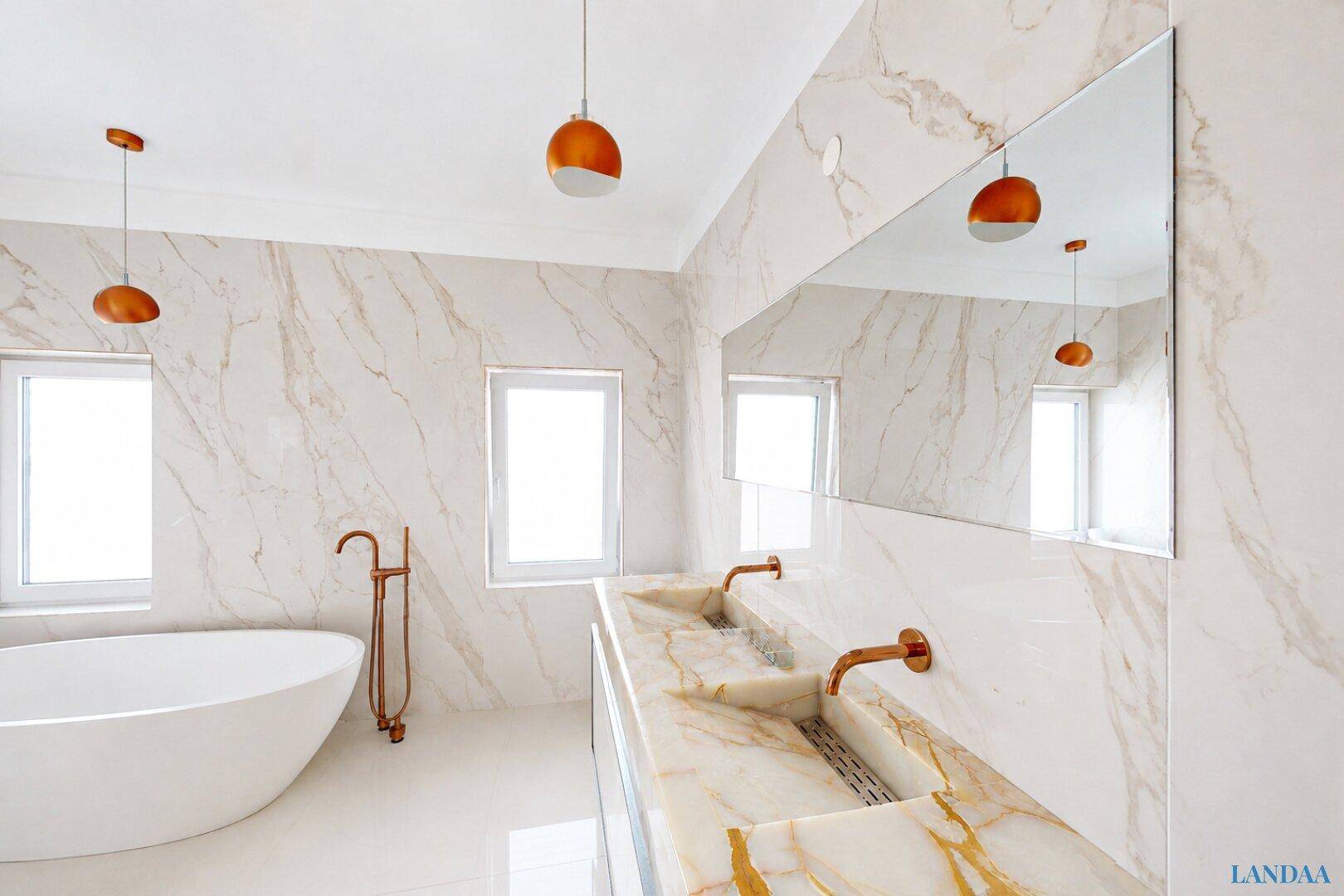 Luxuriöses Badezimmer mit Marmorfliesen, freistehender Badewanne und Doppelwaschbecken.