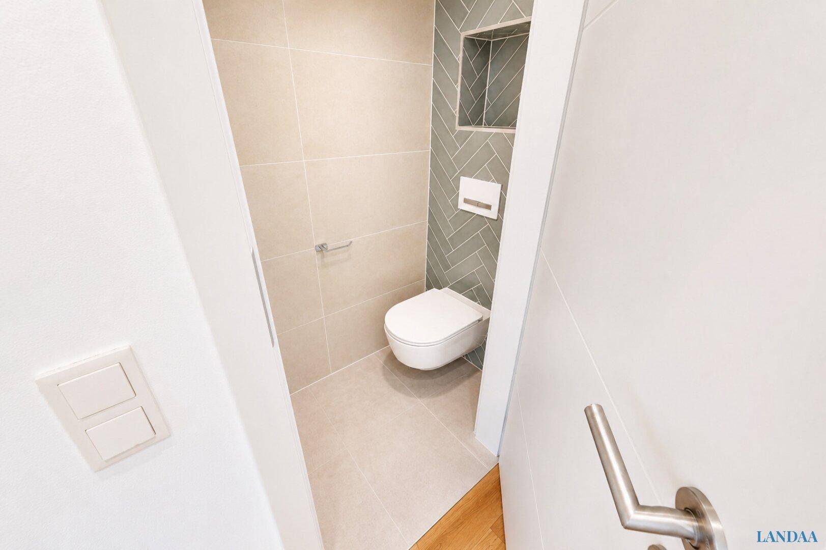 Modernes Gäste-WC mit Wand-WC und stilvollen Fliesen in Beige und Grau.