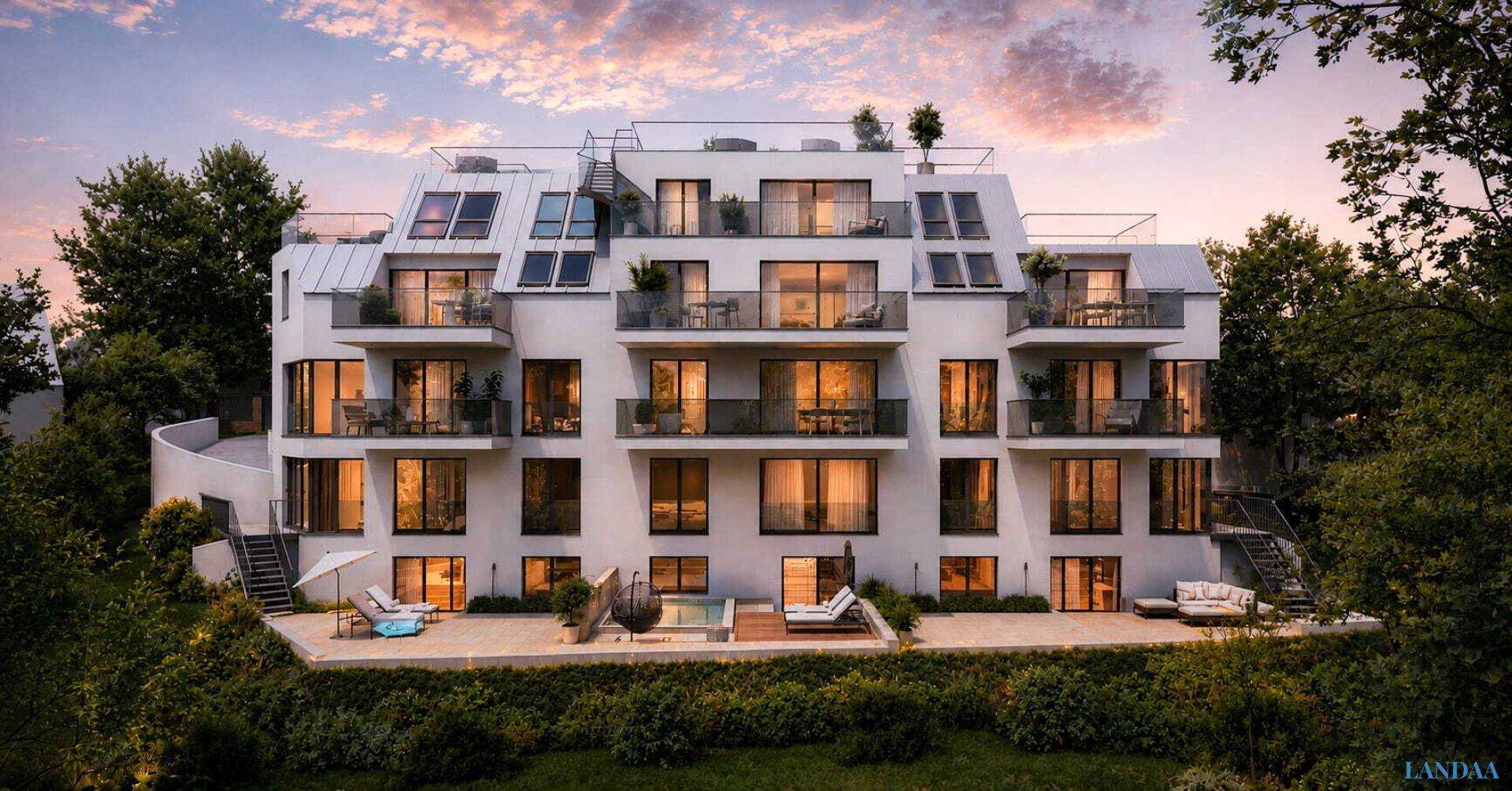 Moderne Wohnanlage mit mehreren Balkonen und Terrassen, umgeben von viel Grün bei Sonnenuntergang.