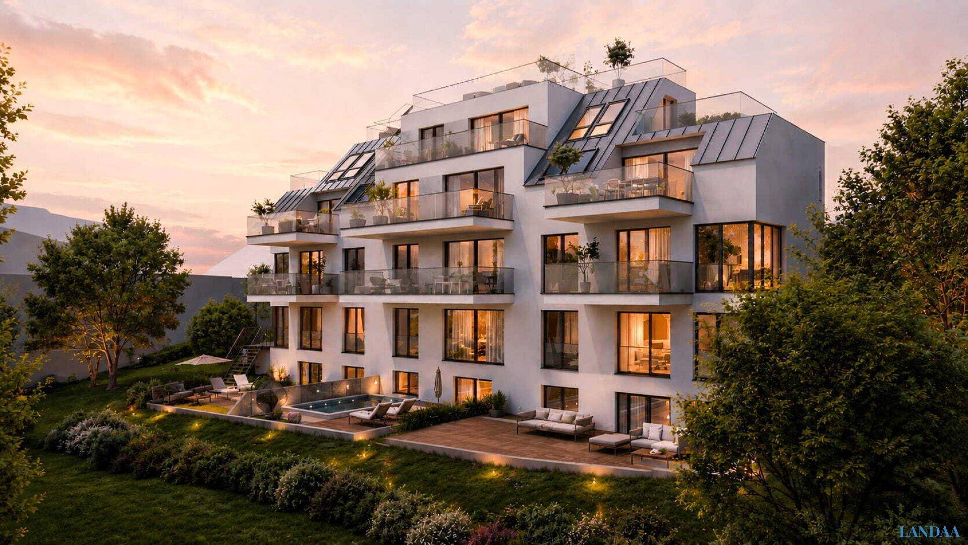 Modernes Wohngebäude mit großzügigen Balkonen und Terrassen, eingebettet in eine grüne Umgebung bei Sonnenuntergang.