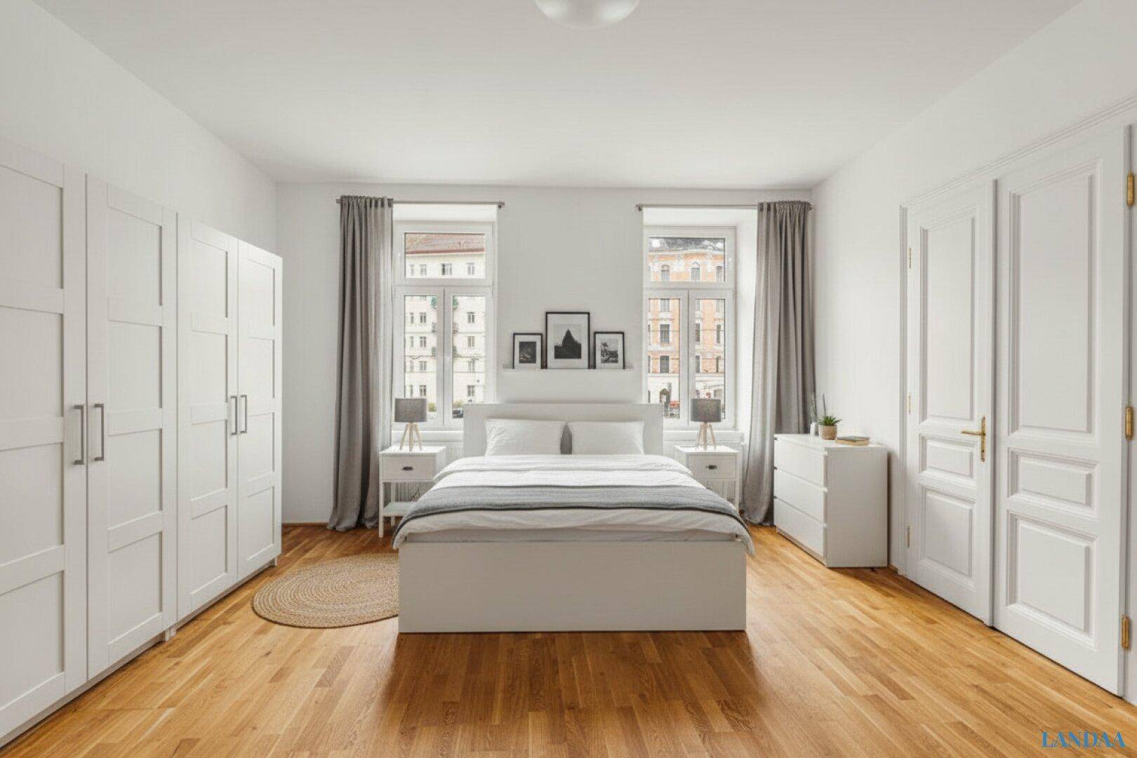 Geräumiges Schlafzimmer mit Holzboden, einem Doppelbett und großen weißen Kleiderschränken.