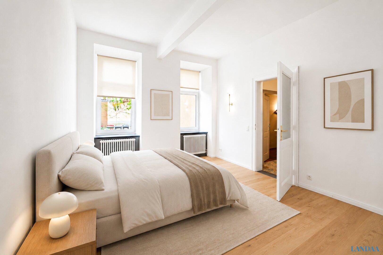 Modern eingerichtetes Schlafzimmer mit hellem Holzboden, großem Bett und viel Tageslicht.