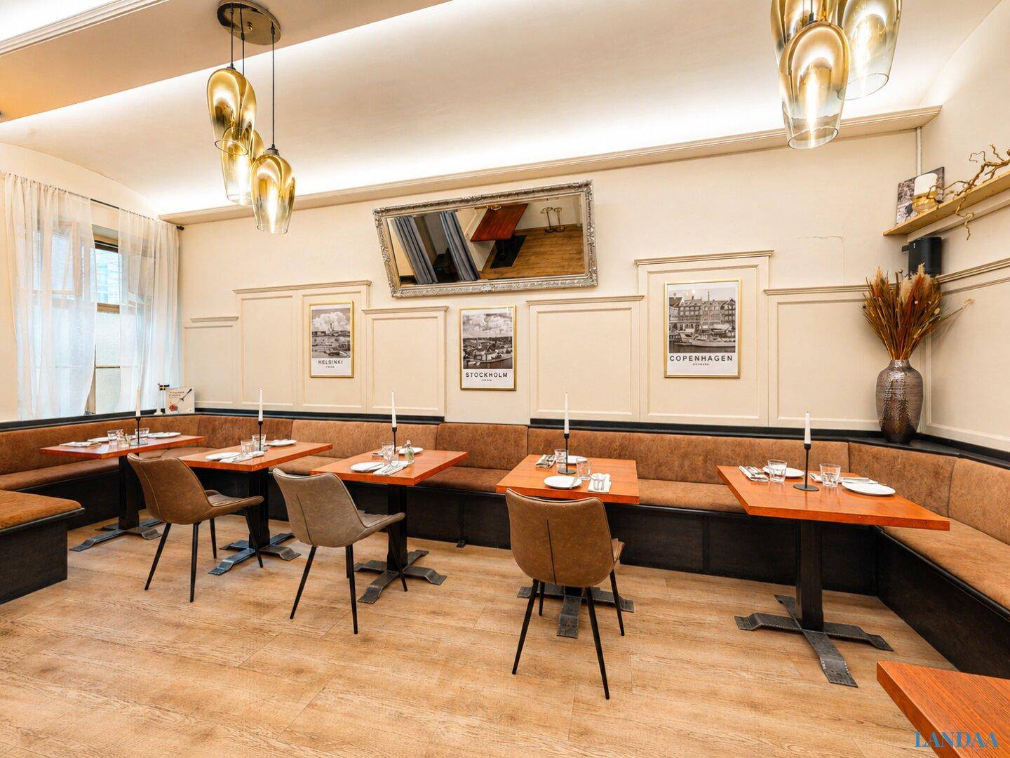 Gemütlicher Restaurantbereich mit bequemen Sitzbänken, Holztischen und stilvollen Hängelampen.