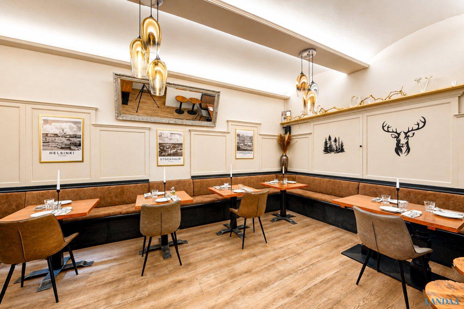 Heller Restaurantbereich mit beigen Wänden, braunen Sitzbänken und Holzboden, dekoriert mit Hirschmotiv.