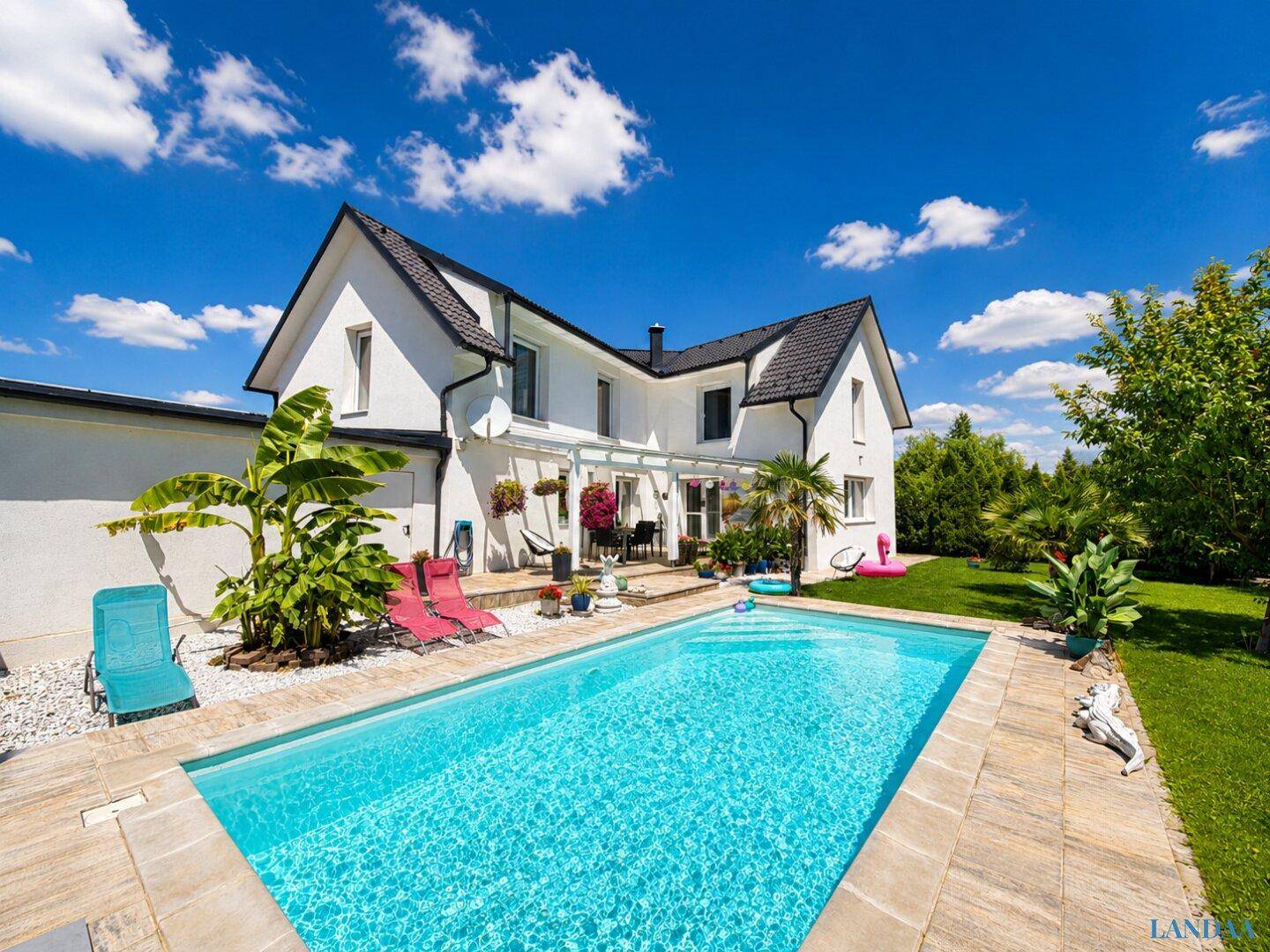Weitläufiger Außenbereich mit großem Pool, Sonnenterrasse und gepflegtem Garten.