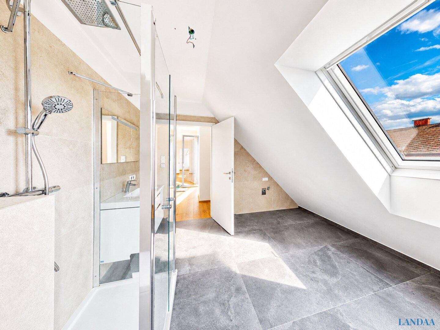 Modernes Badezimmer im Dachgeschoss mit Dusche, Fliesenboden und Dachfenster.