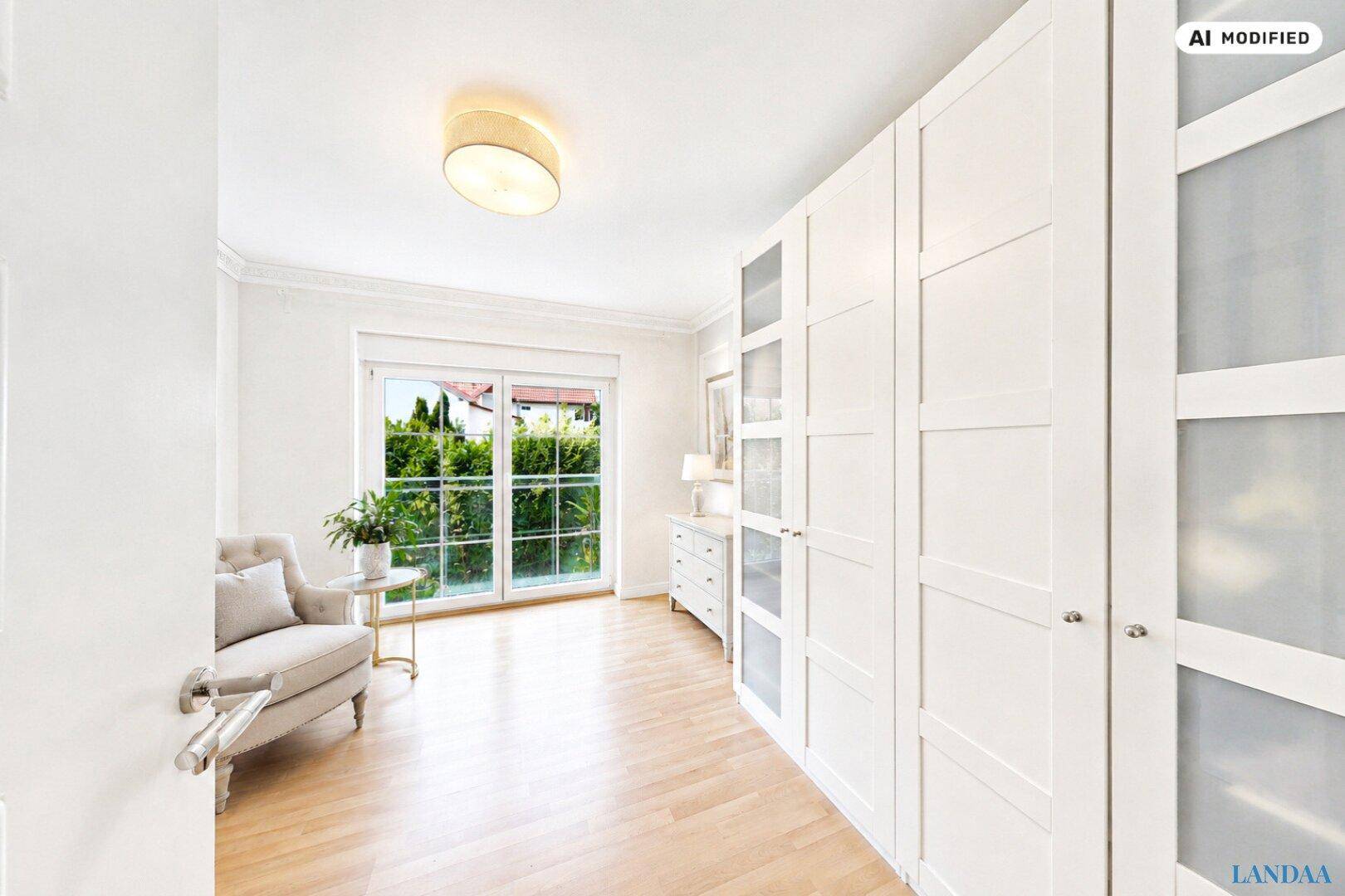 Heller Raum mit großen weißen Einbauschränken und Zugang zum Garten durch eine Fenstertür.