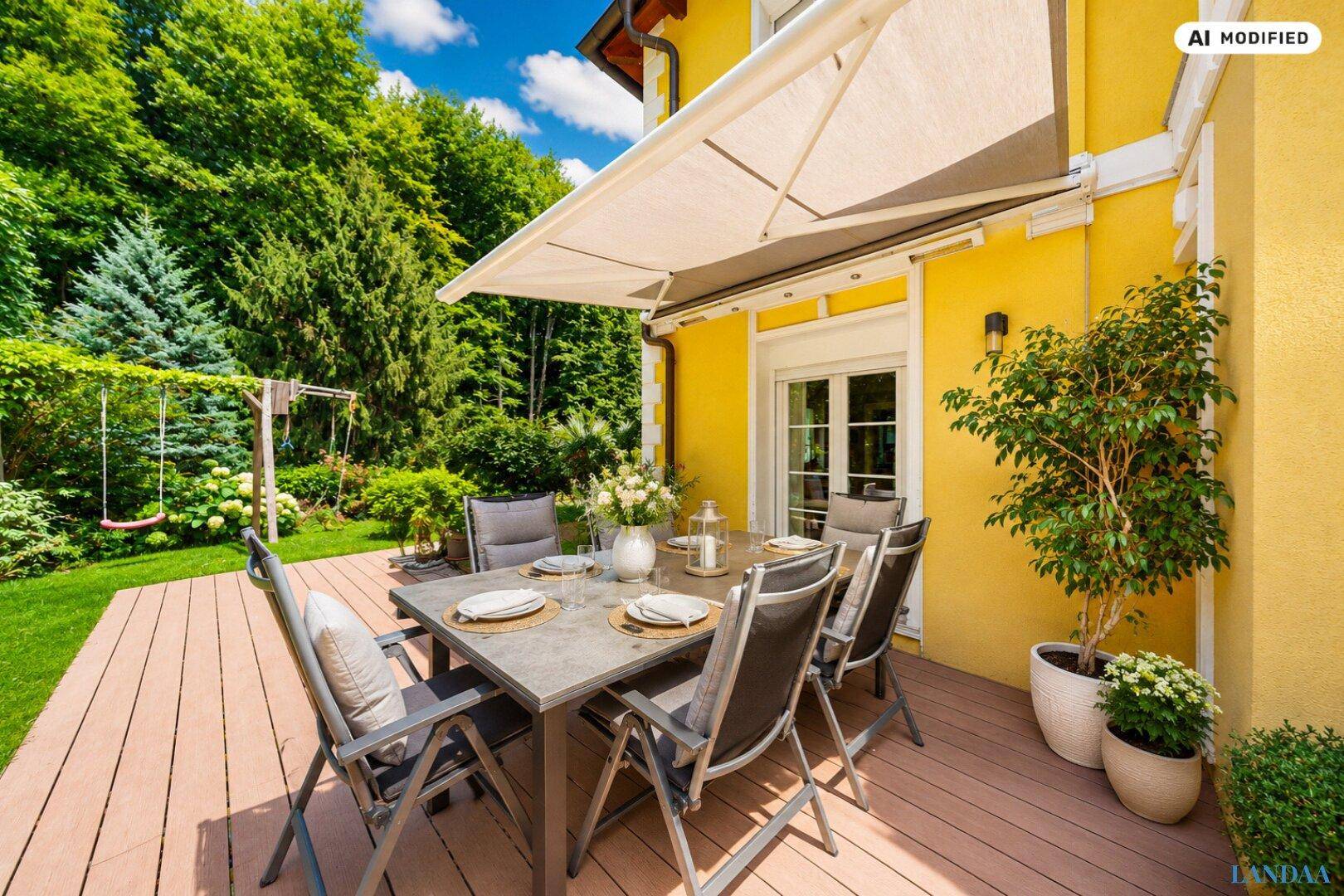 Gemütliche Holzterrasse mit Esstisch, Markise und Blick ins Grüne, ideal für Mahlzeiten im Freien.