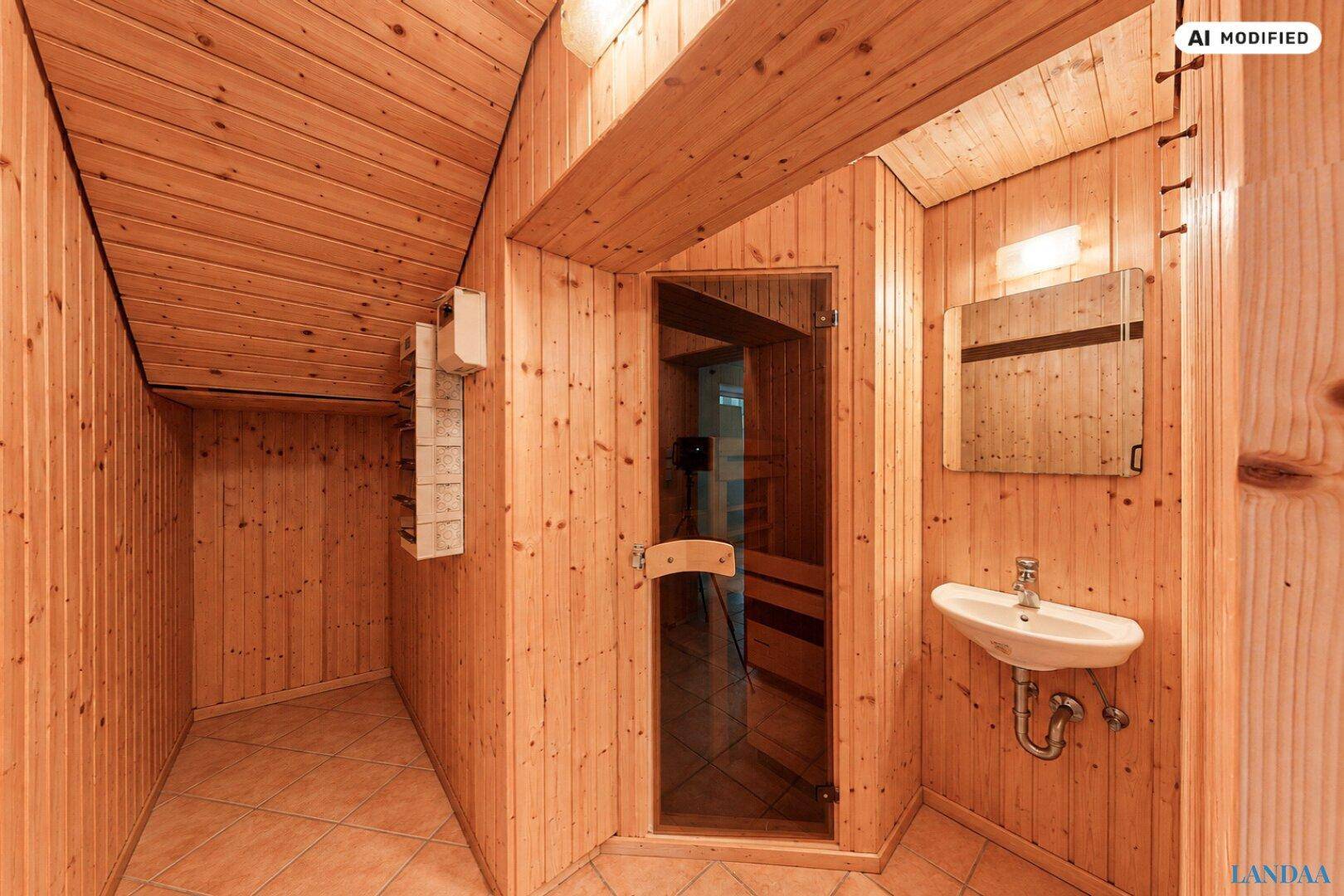 Gemütlicher Saunabereich mit Holzverkleidung, Waschbecken und einer Glastür zur Sauna.