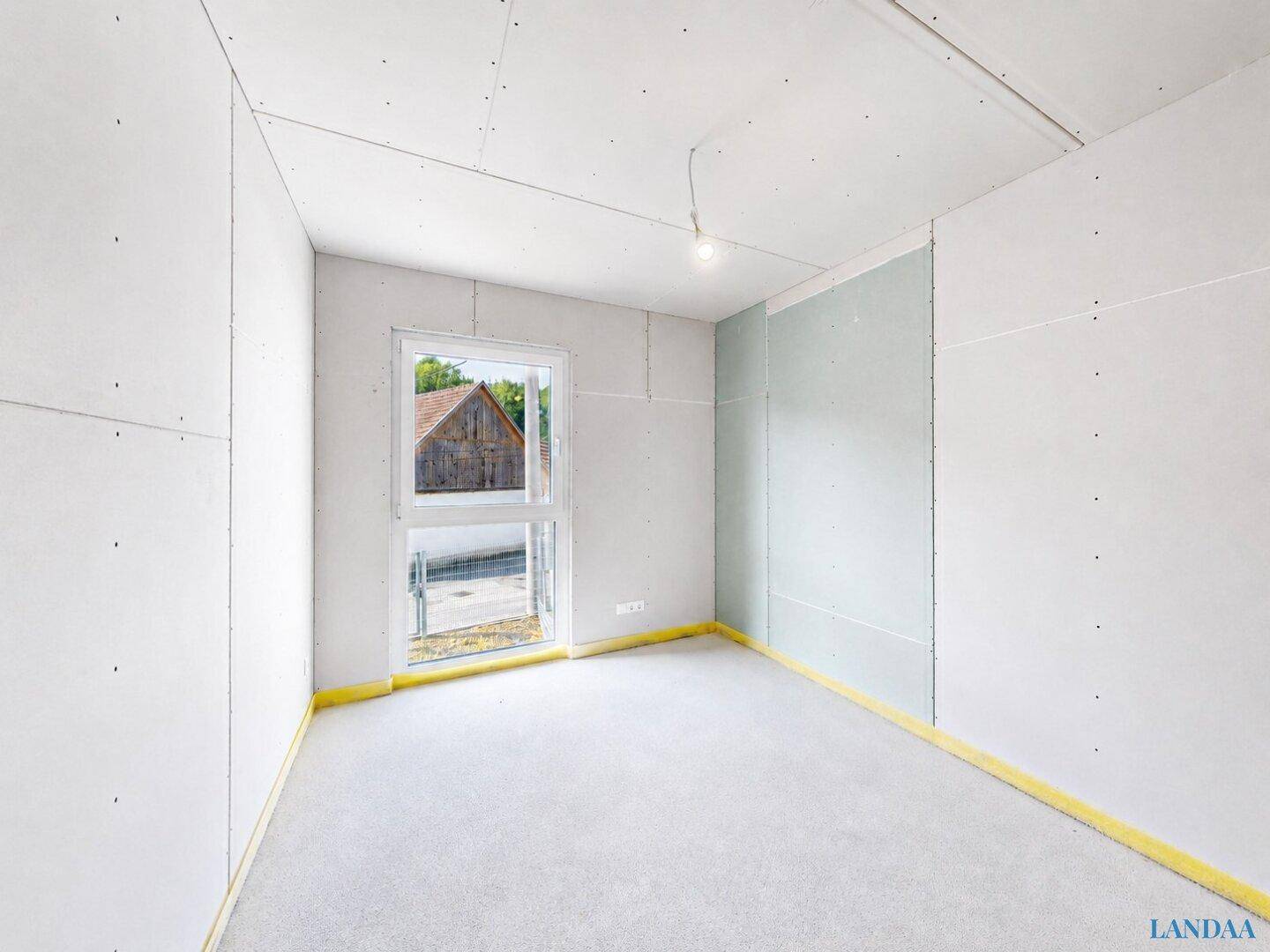 Unfertiges Zimmer mit großem Fenster und Blick auf die Umgebung.