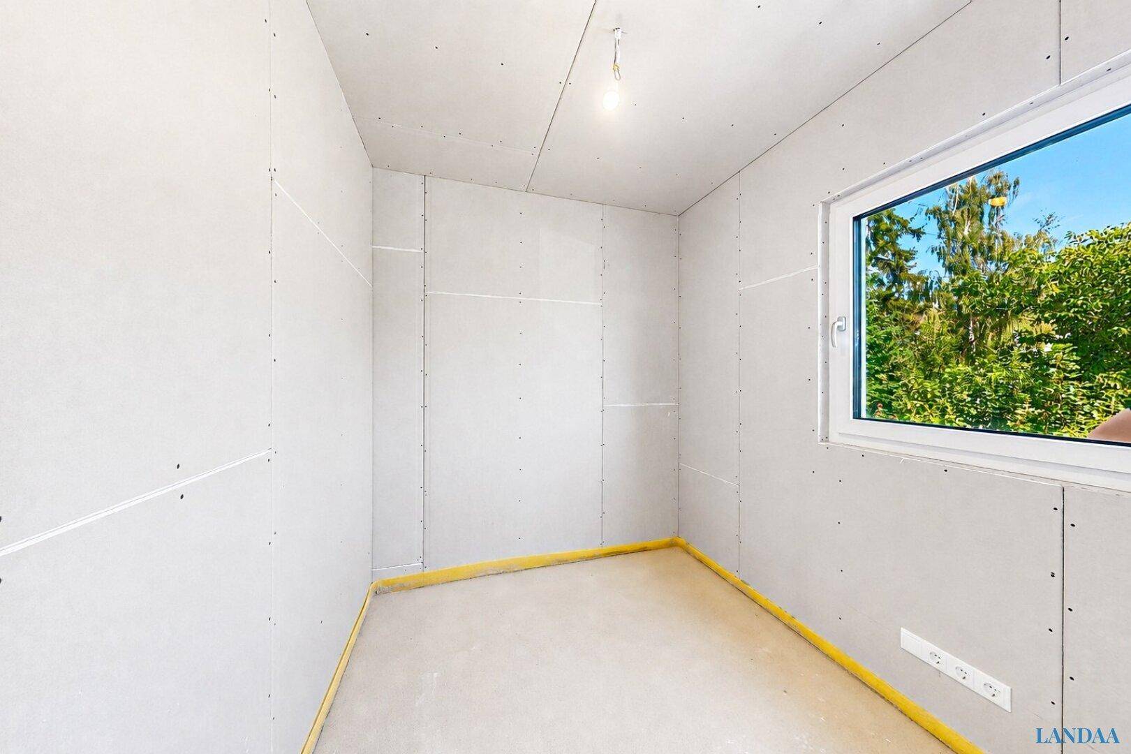 Rohbau-Zimmer mit Fenster, bereit für den Innenausbau und individuelle Gestaltungsmöglichkeiten.