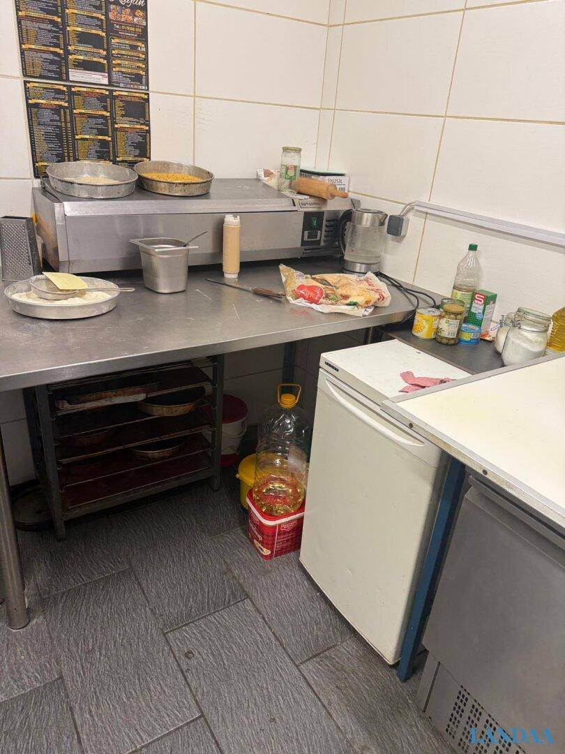 Detailansicht eines Arbeitsbereichs in der Gewerbeküche mit Edelstahltisch und professionellen Kochgeräten.
