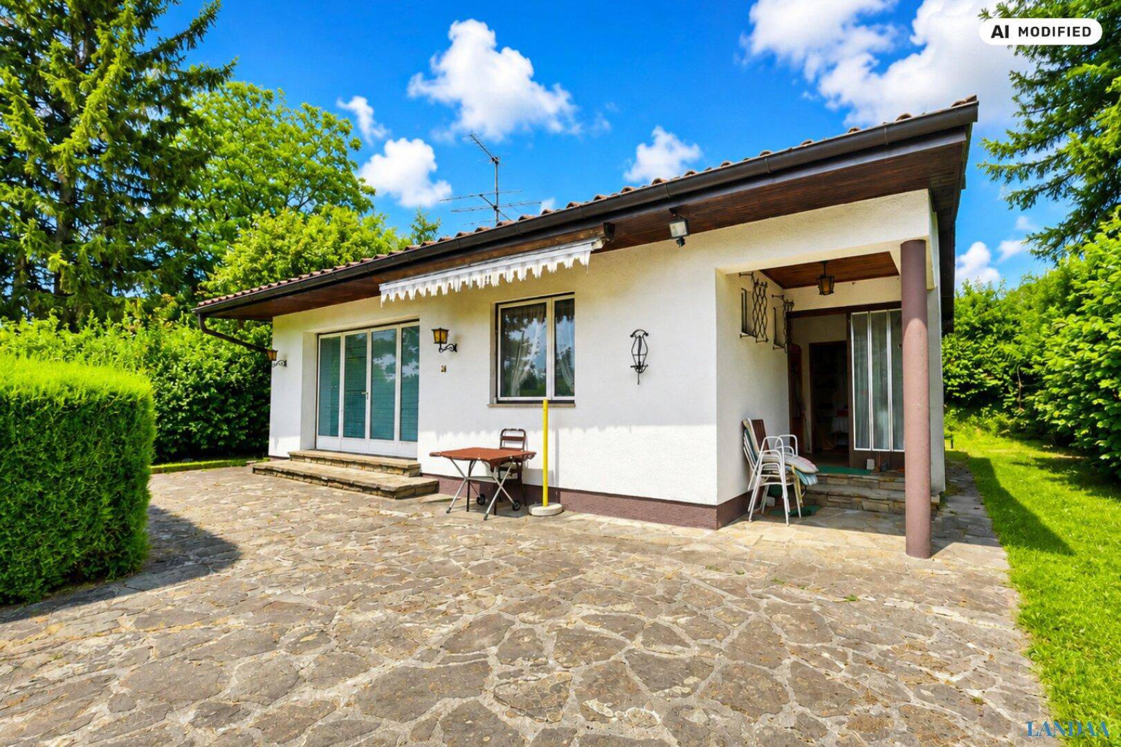 Gemütliche Terrasse mit Steinplatten und einer Markise, ideal für entspannte Stunden im Freien.