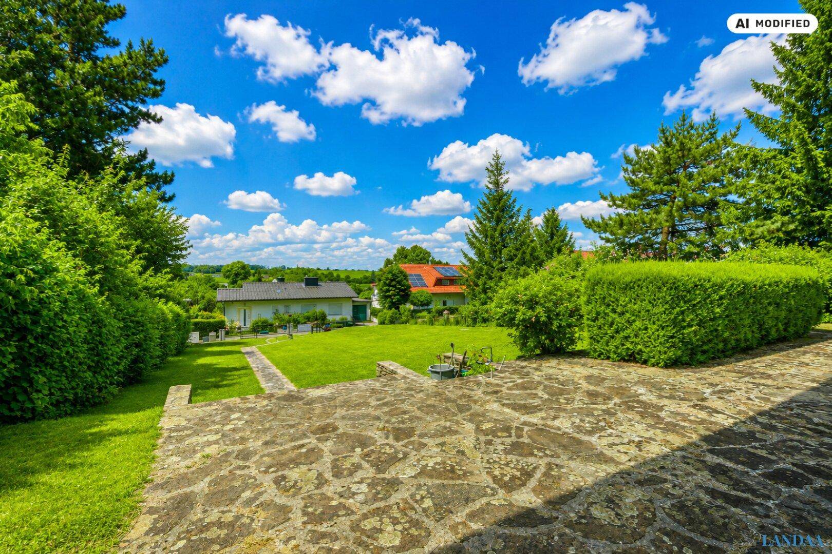 Großer Garten mit gepflegtem Rasen und weitem Blick über die umliegende Landschaft und Häuser.