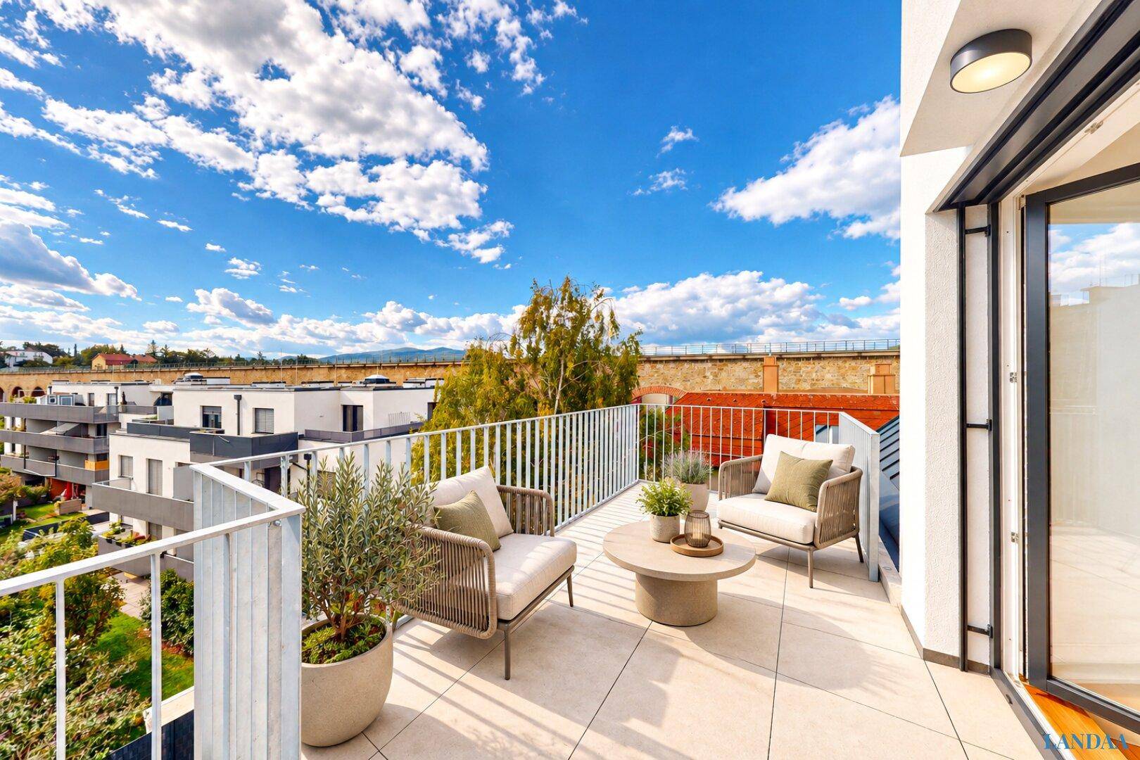 Großer Balkon mit modernen Outdoor-Möbeln und weitem Blick über die Umgebung.