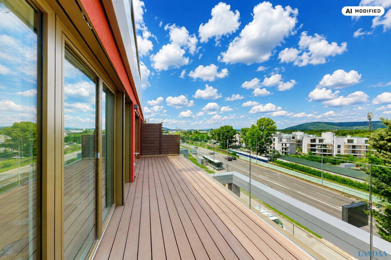 Große Dachterrasse mit Holzboden und Glasgeländer, bietet einen weiten Blick auf die Umgebung.