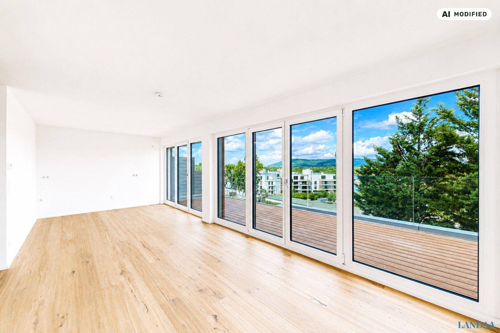 Heller, unmöblierter Raum mit Holzboden und großen Fenstern, die einen weiten Ausblick bieten.
