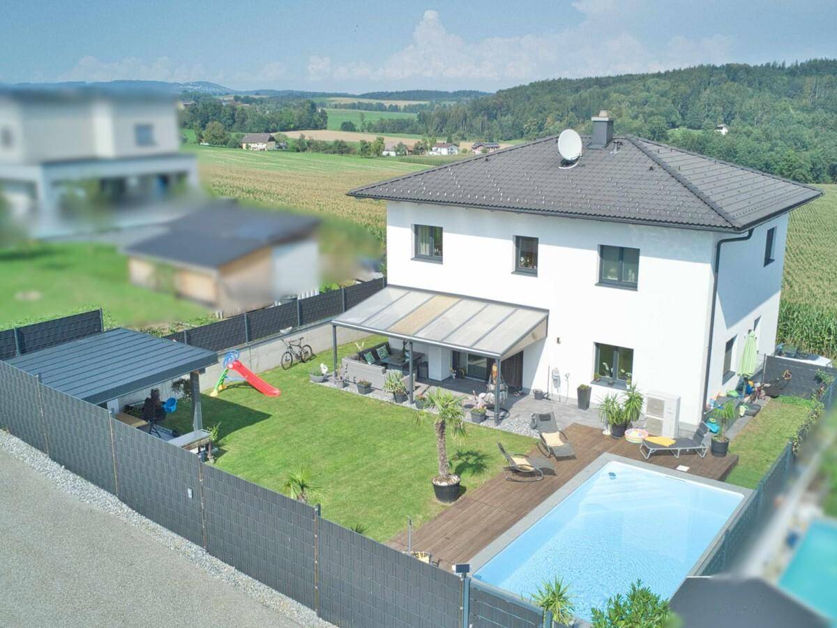 Luftaufnahme des Einfamilienhauses mit großem Garten, Pool und ländlicher Umgebung.