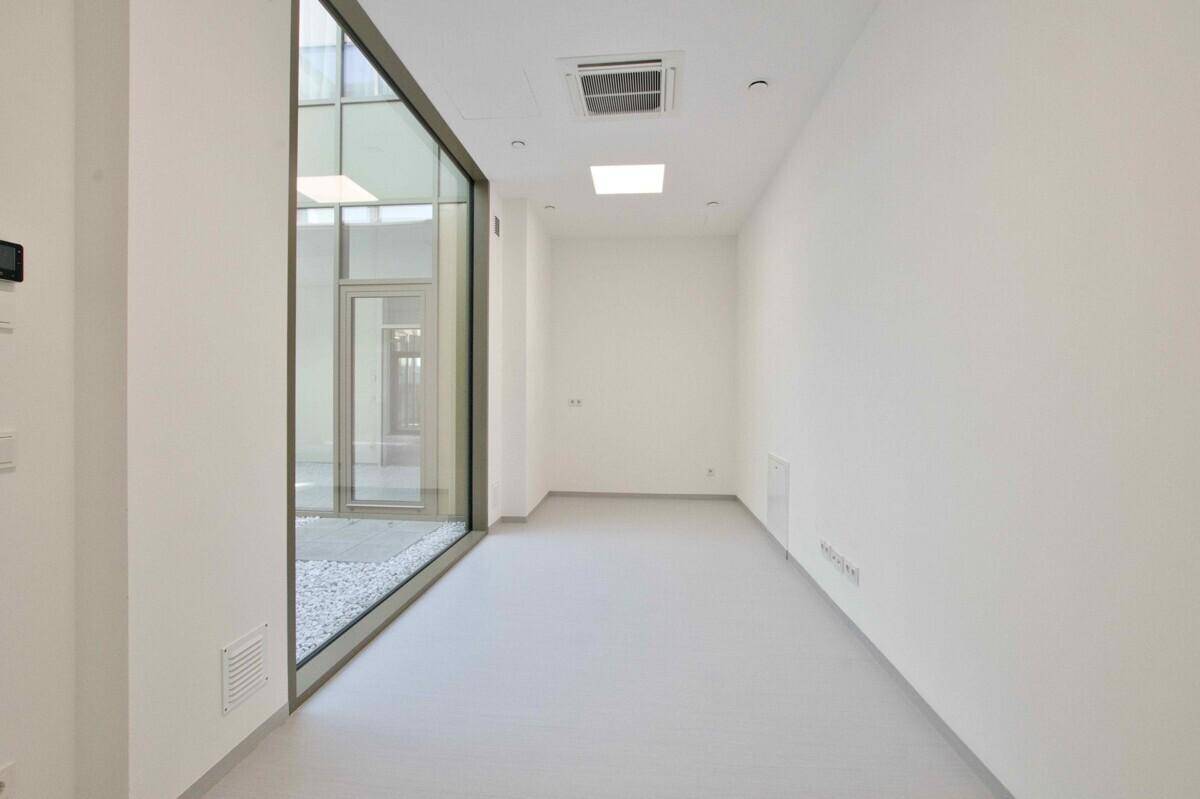 Heller Flur mit großer Fensterfront zum Innenhof, bietet angenehmes Tageslicht.