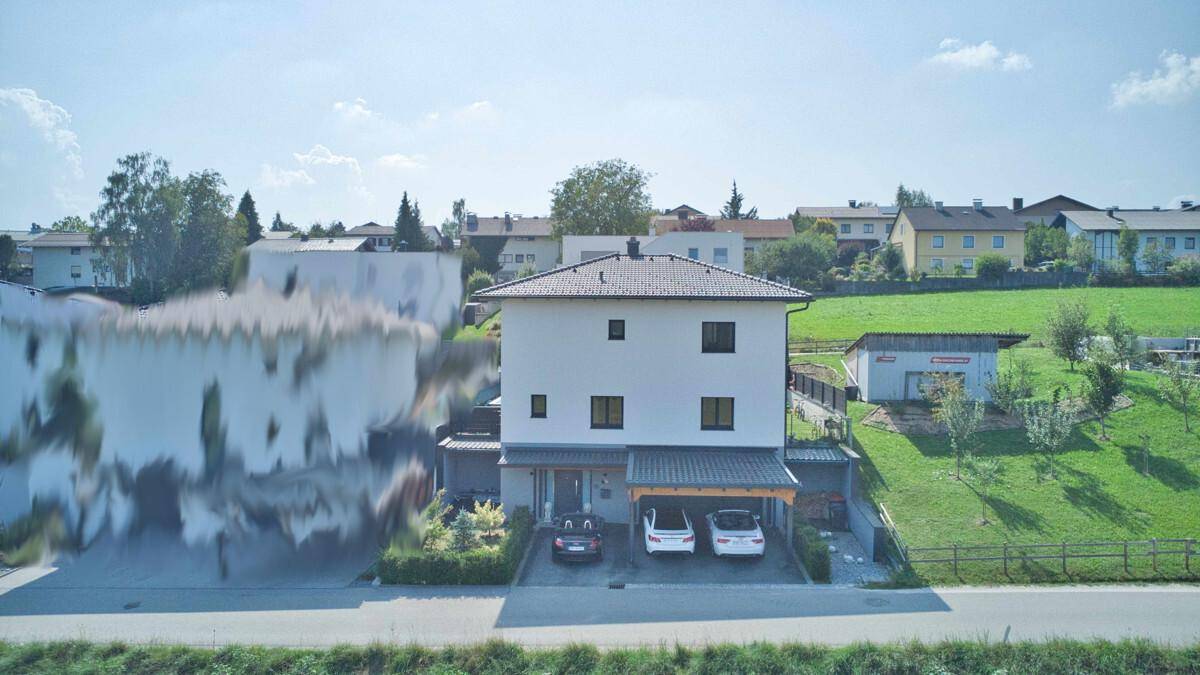 Weitläufige Ansicht des Einfamilienhauses mit Carport und ländlicher Umgebung.