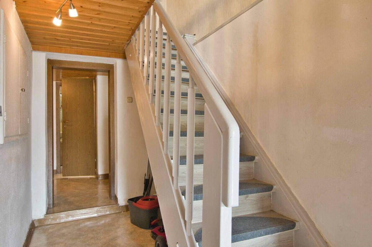 Flur mit Holzdecke und Treppe, die in die obere Etage führt.