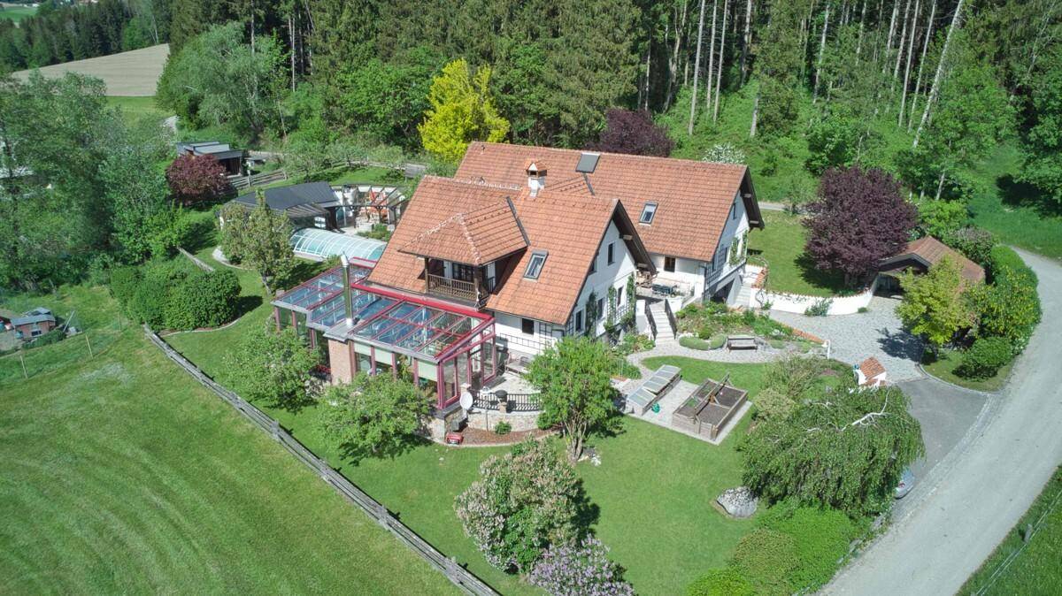 Gesamtansicht des Anwesens aus der Luft mit Haus, großem Garten, Pool und ländlicher Umgebung.
