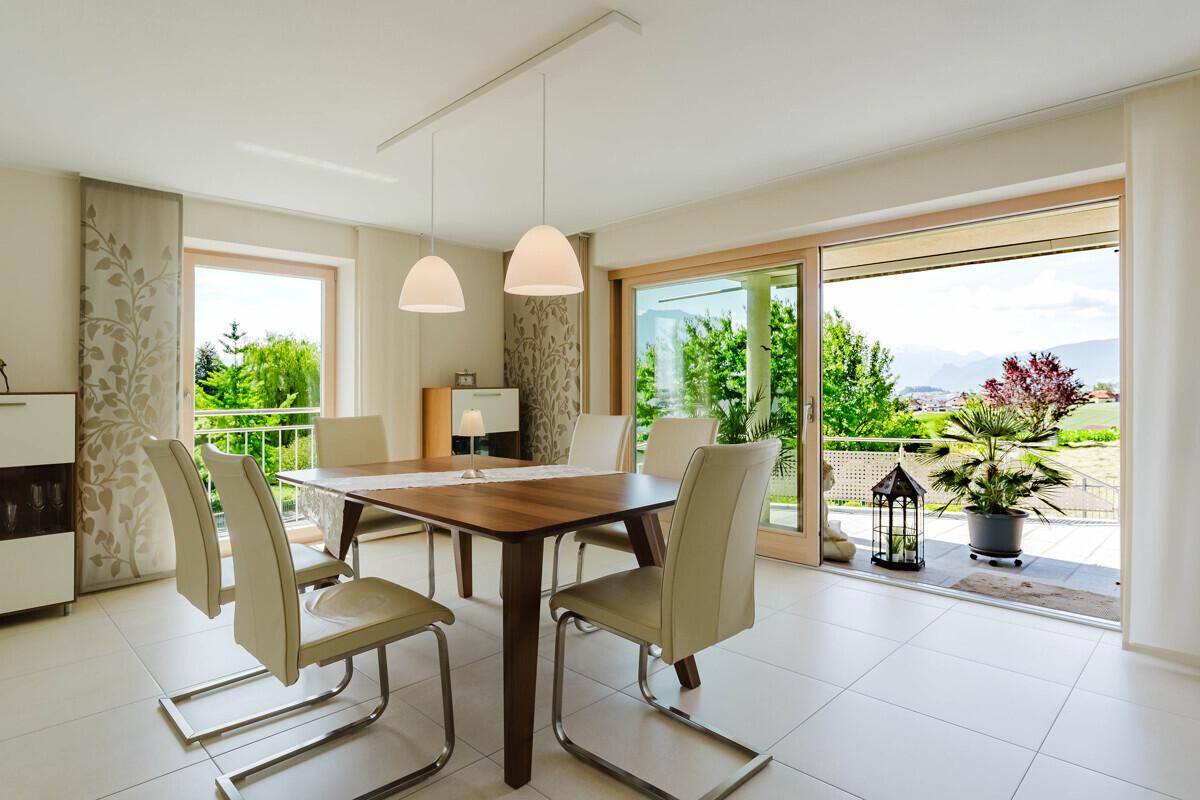 Eleganter Essbereich mit Holztisch, modernen Stühlen und direktem Zugang zur Terrasse.