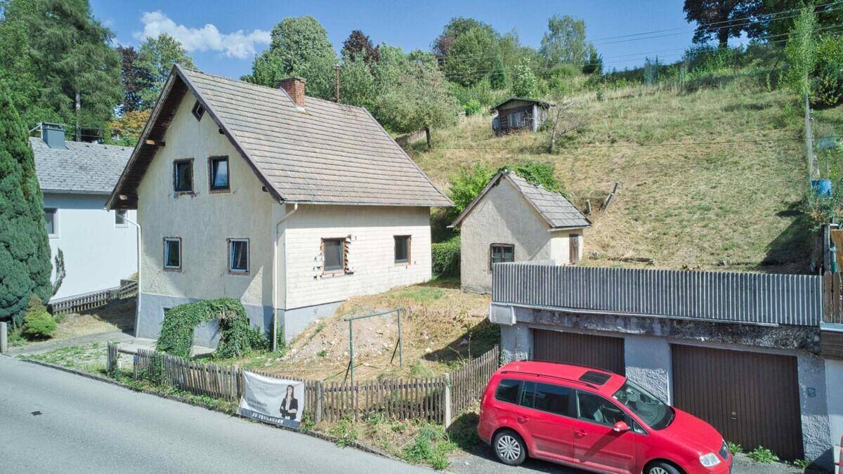 Gesamtansicht des Anwesens von der Straße mit Haupthaus, Nebengebäude und Garagen.