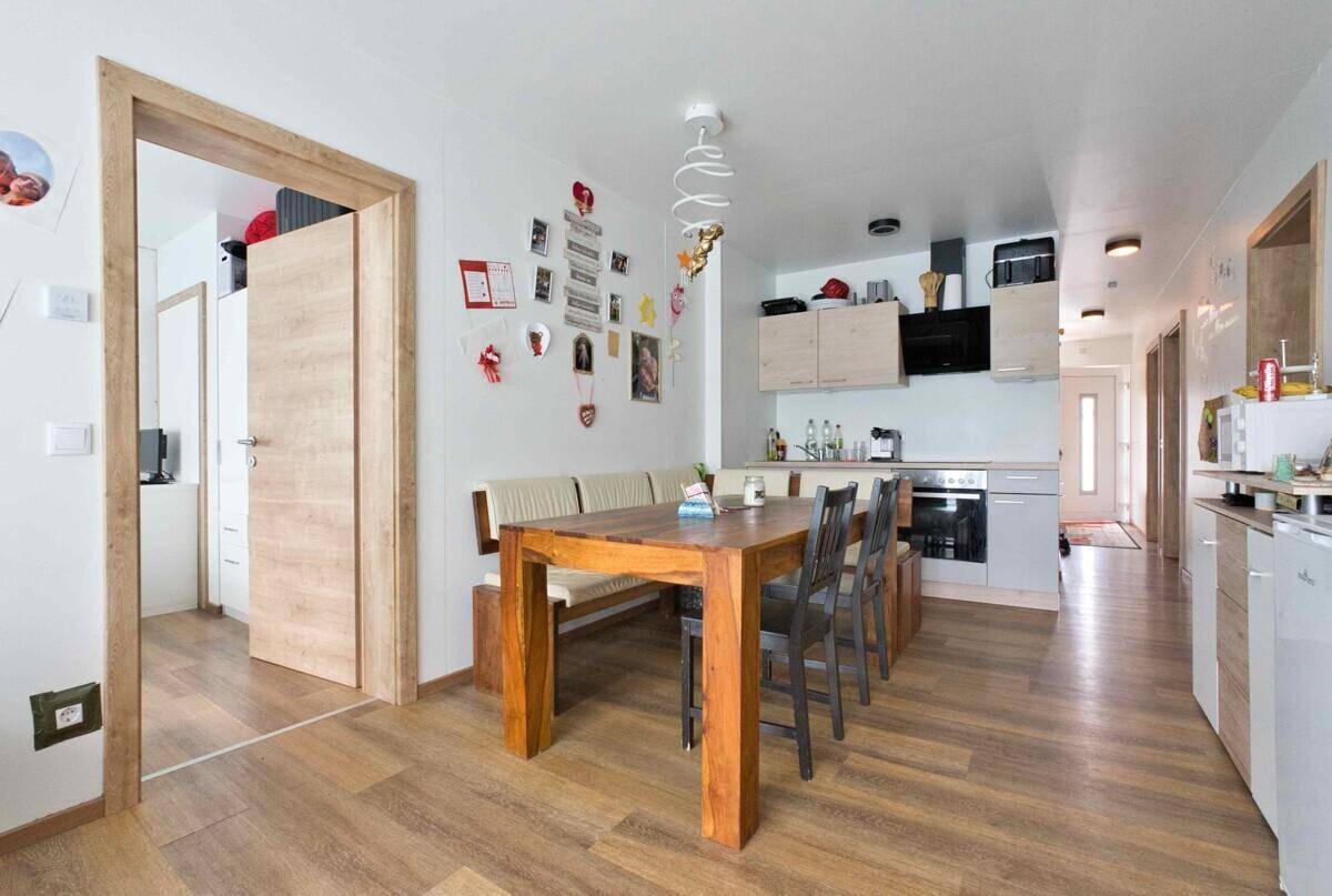 Offene Küche mit Essbereich, großem Holztisch und gemütlicher Sitzbank.