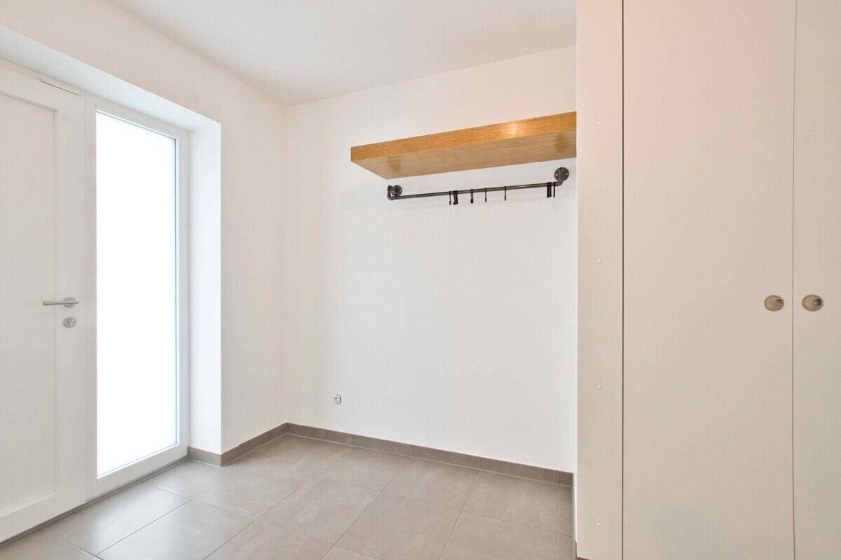 Eingangsbereich mit Garderobe, Holzablage und praktischen Einbauschränken.