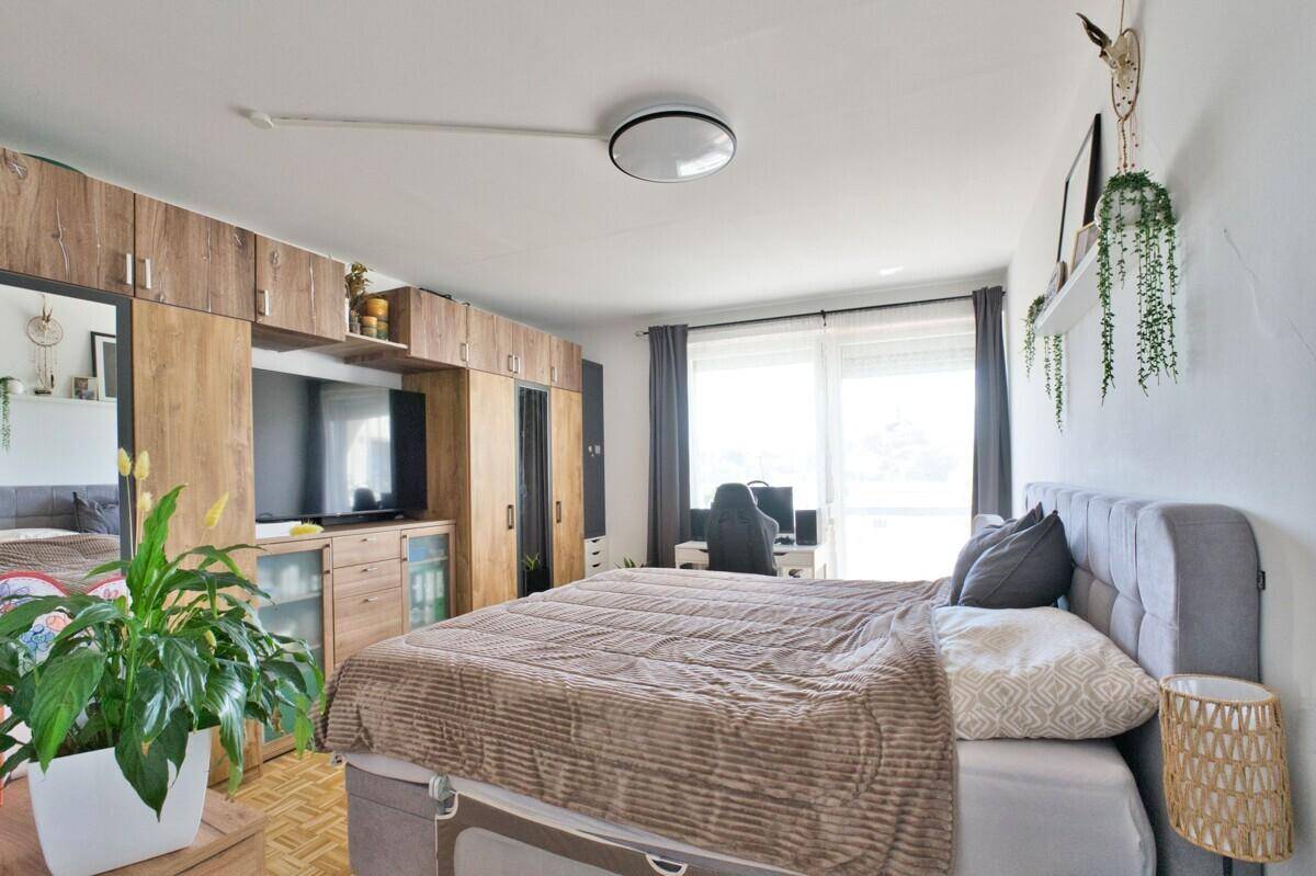 Geräumiges Schlafzimmer mit großem Bett, Einbauschränken und Zugang zum Balkon.