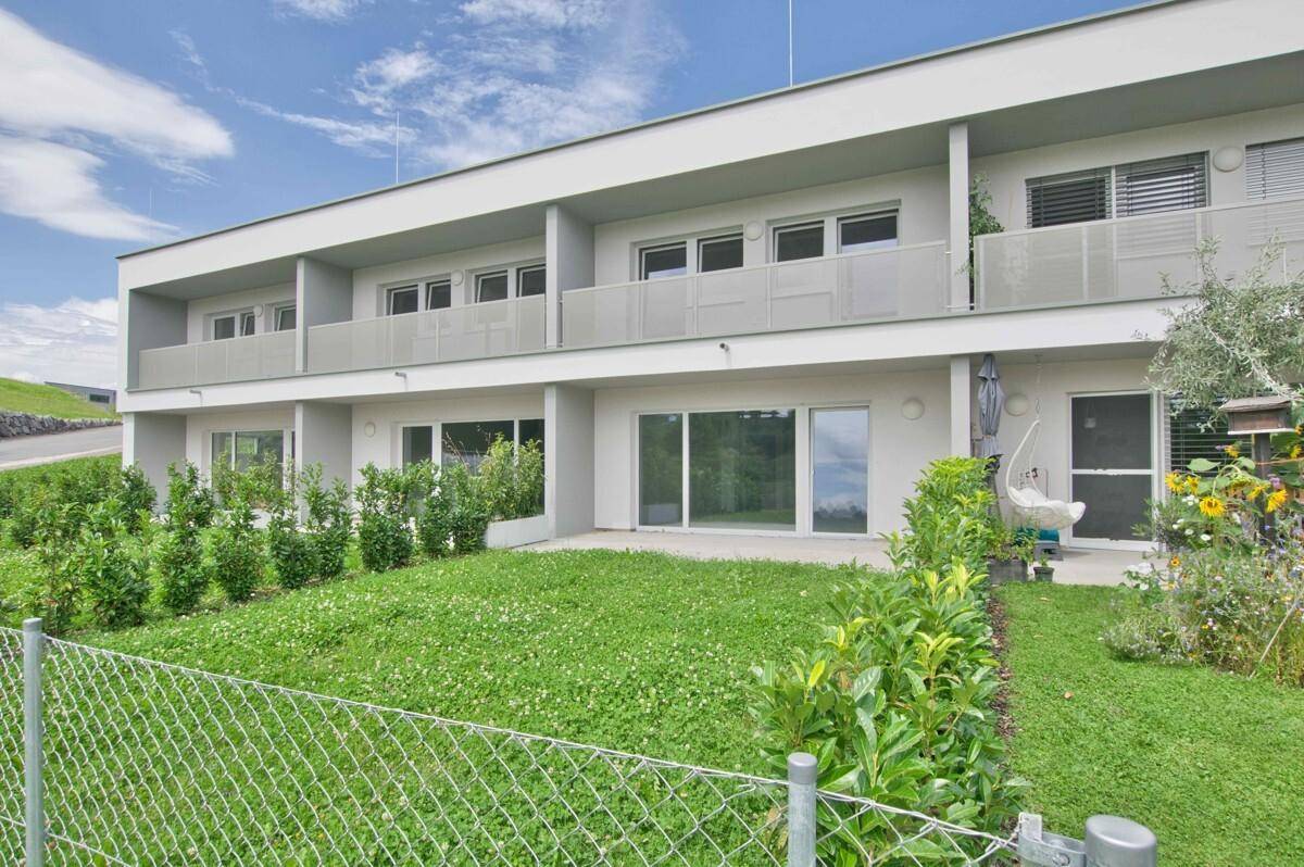 Moderne Wohnanlage mit Terrassenwohnungen im Erdgeschoss und Balkonen in den oberen Etagen.