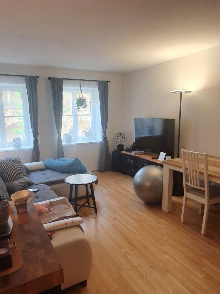 Geräumiger Wohn-Essbereich mit Fernseher, Stehlampe und Holzboden, bietet Platz für Entspannung und Aktivitäten.