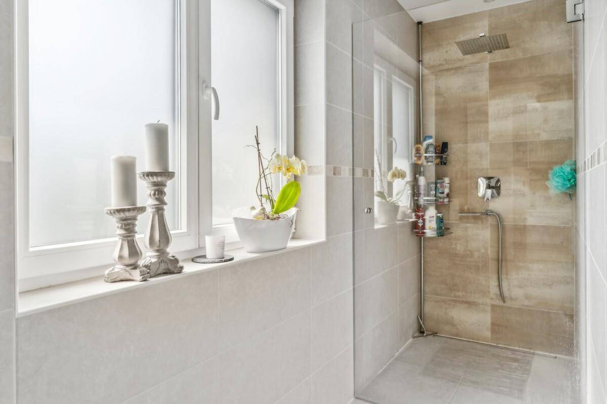 Modernes Badezimmer mit ebenerdiger Dusche, Regendusche und Fenster.