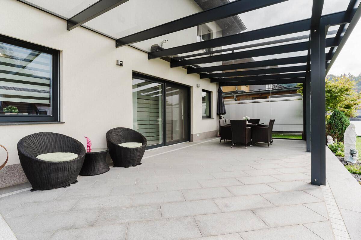 Große gepflasterte Terrasse mit Sitzgelegenheiten und direktem Zugang zum Haus.