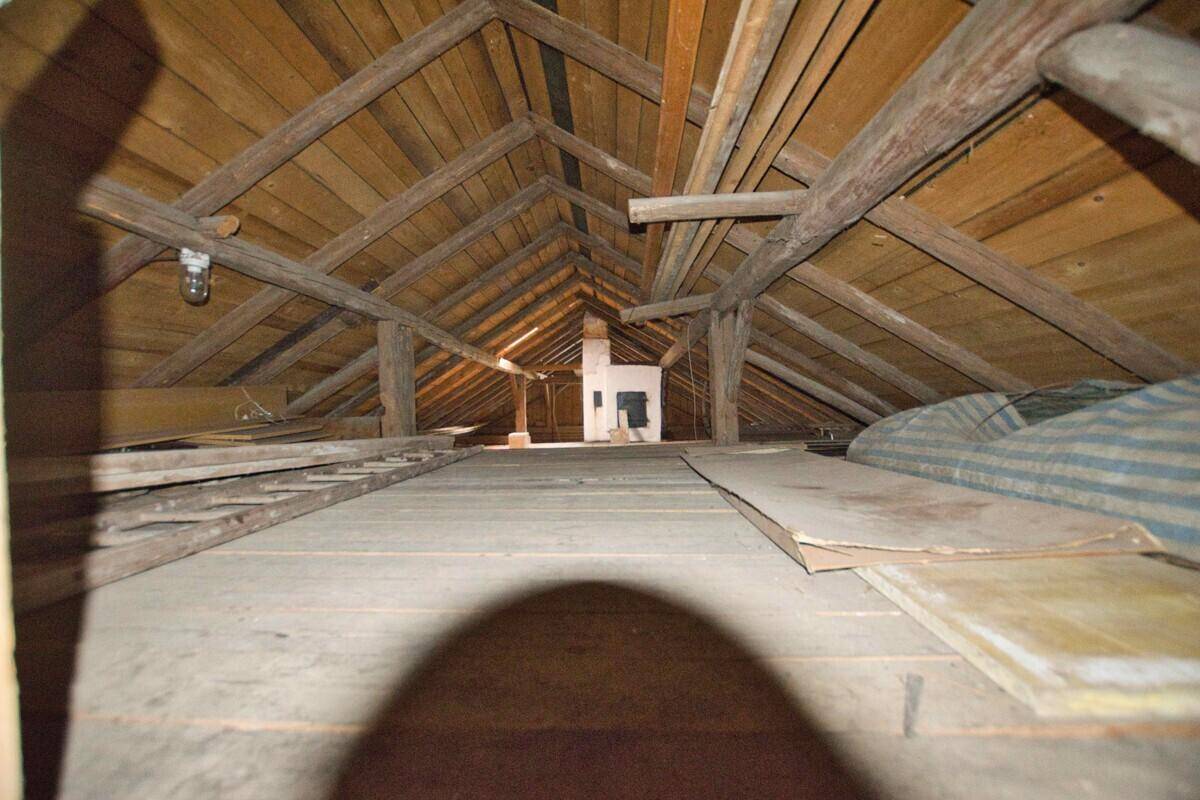 Geräumiger Dachboden mit freiliegenden Holzbalken und Holzboden.