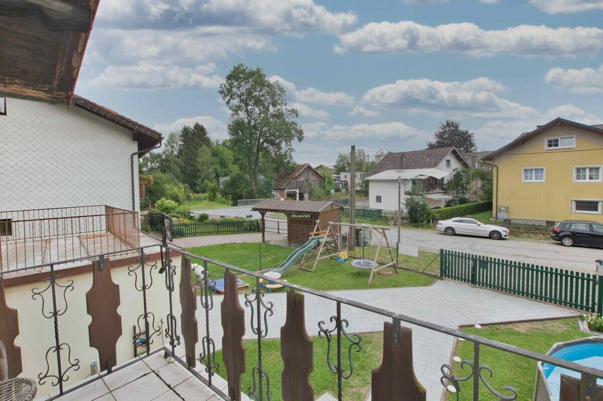 Blick vom Balkon auf den Garten, Kinderspielplatz und die Straße.