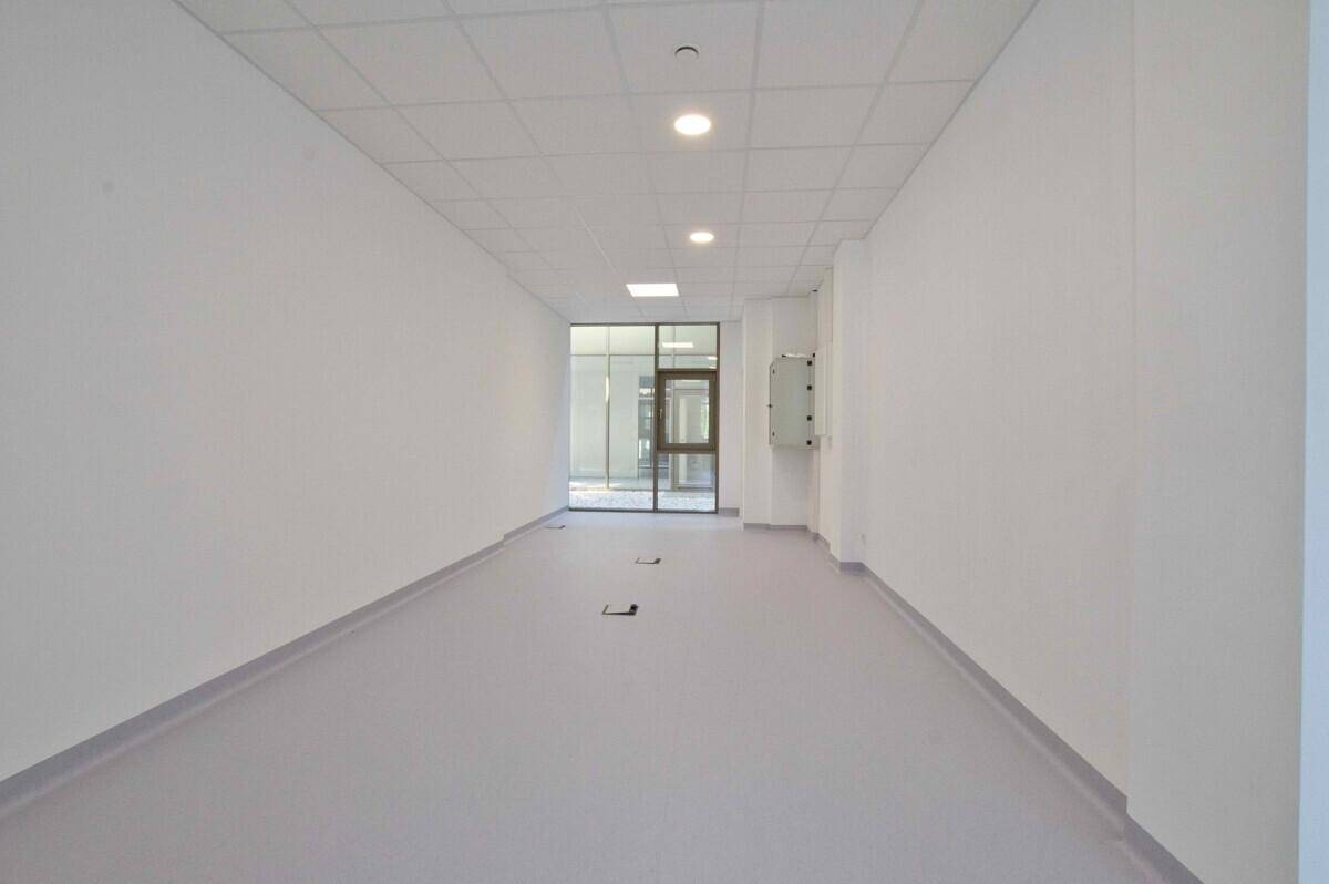 Langer, heller Flur mit Deckenbeleuchtung und Zugang zu weiteren Räumen.