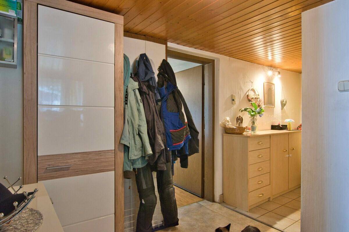 Eingangsbereich mit Garderobe, Schuhschrank und Holzpaneeldecke.