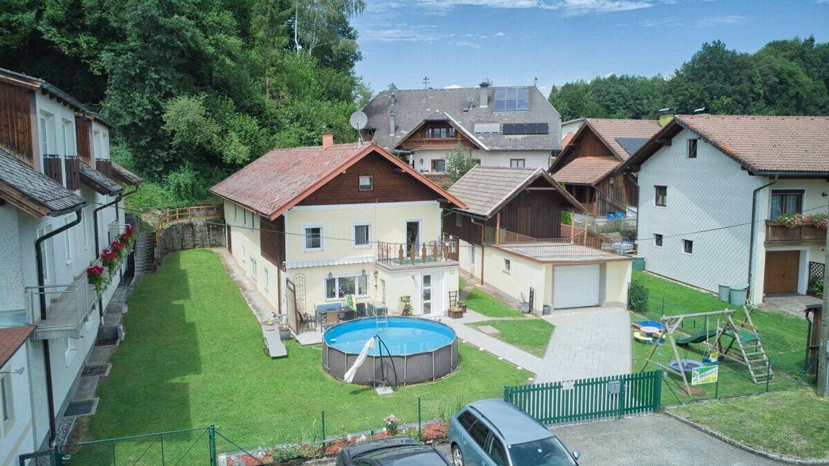 Luftaufnahme des Hauses mit Garten, Aufstellpool, Einfahrt und Kinderspielplatz.
