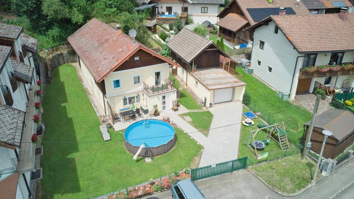 Luftaufnahme des Anwesens mit Haus, Garage, Pool und umliegender Wohnbebauung.