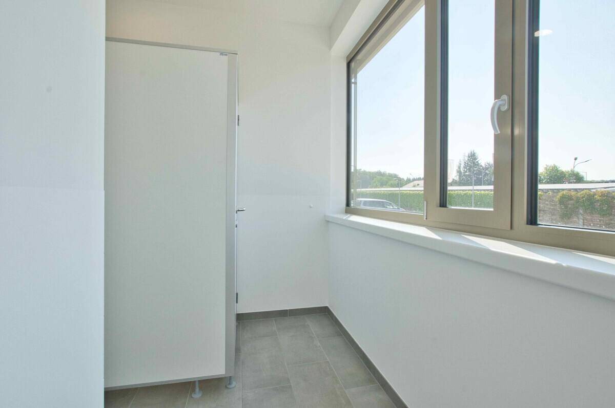 Heller WC-Bereich mit Fenster und Trennwand, sauber und funktional ausgestattet.