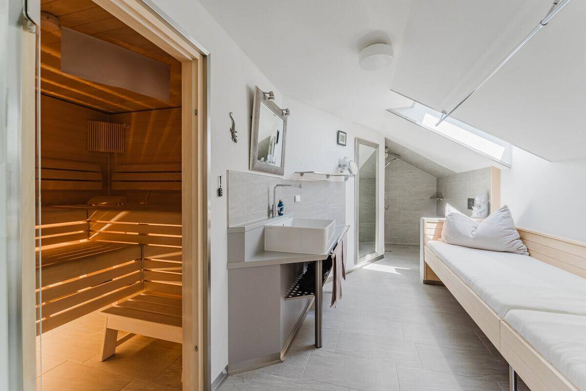 Privater Wellnessbereich mit Sauna, Dusche und Liegefläche für entspannende Momente.