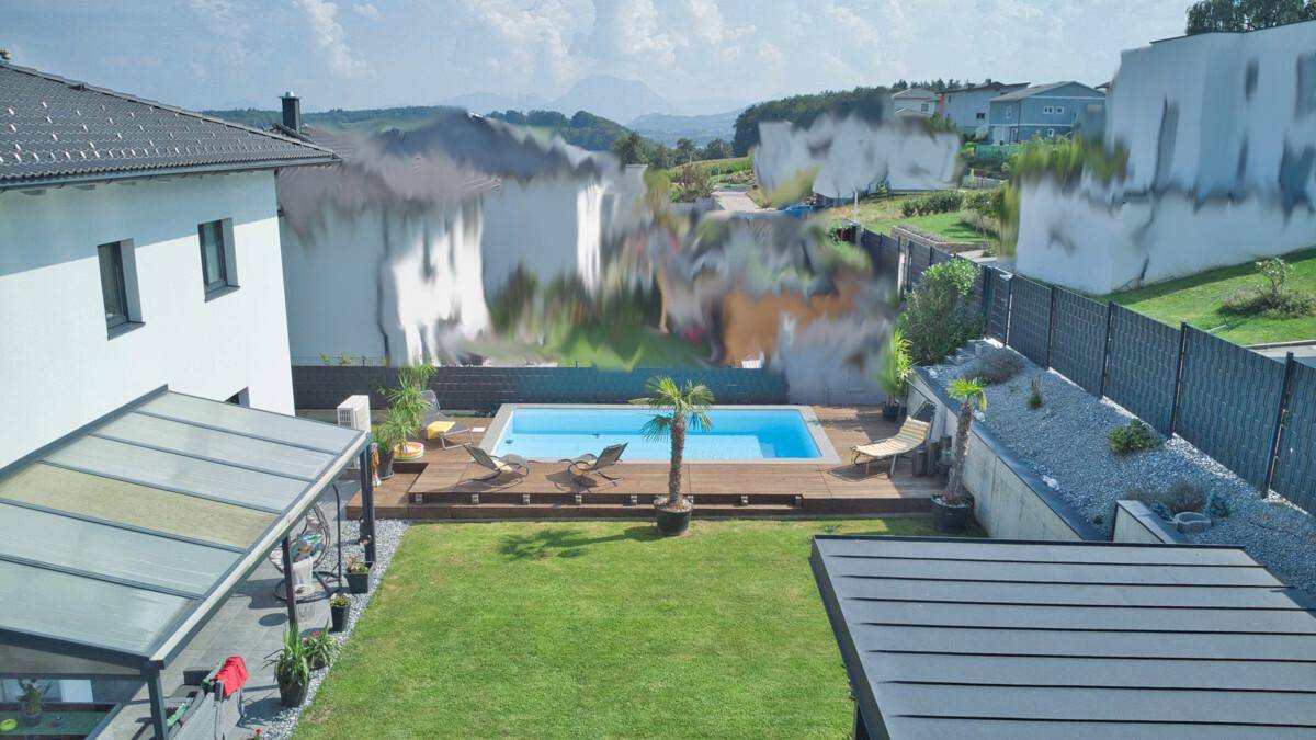 Gartenbereich mit Pool, Holzdeck und Blick auf die umliegende Landschaft.