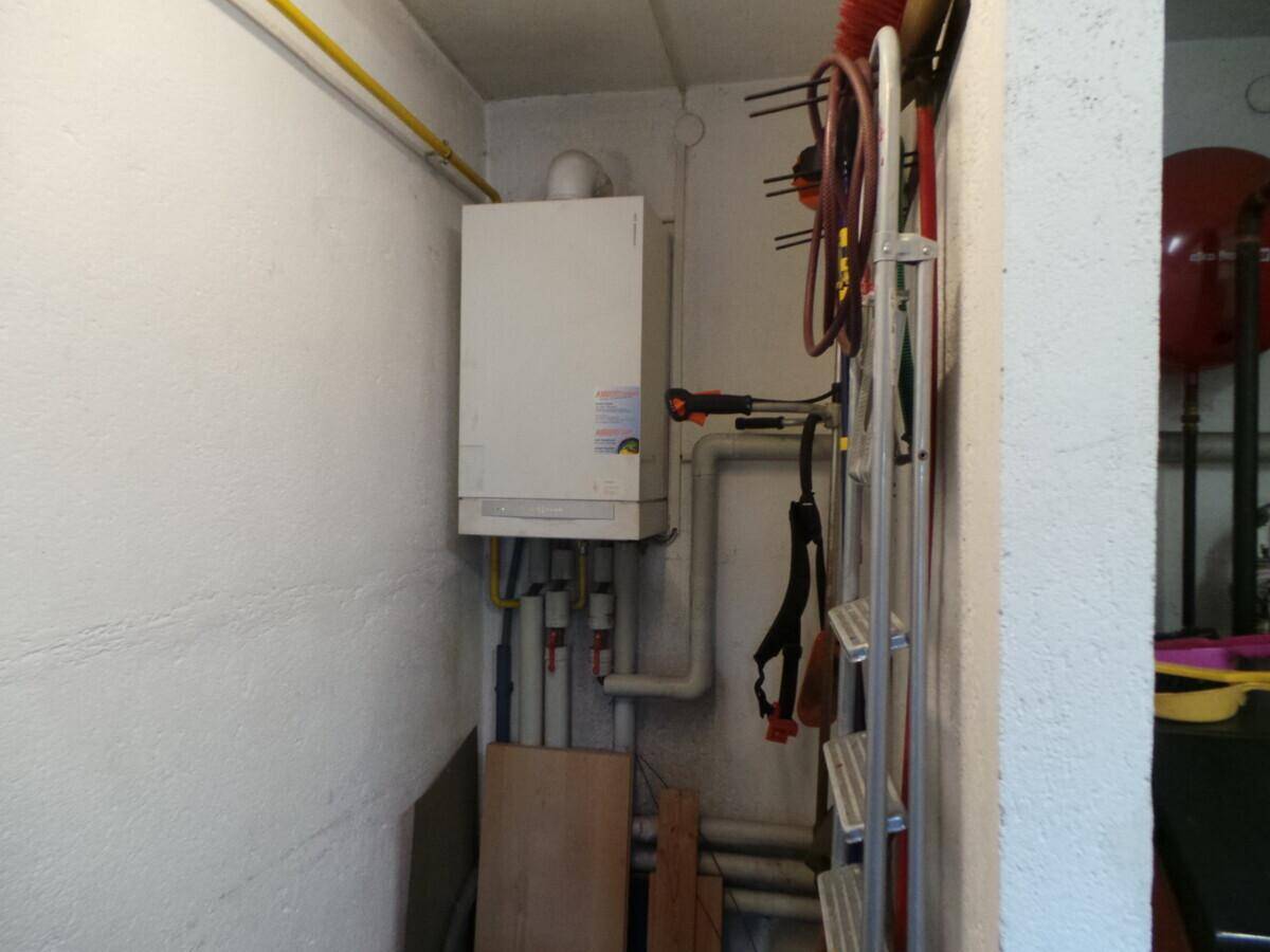 Heizungsraum mit Gastherme und sichtbaren Rohren, dient als Technikraum des Hauses.