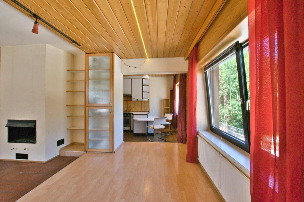 Offener Wohnbereich mit Holzboden, der in einen Essbereich mit Küche übergeht.