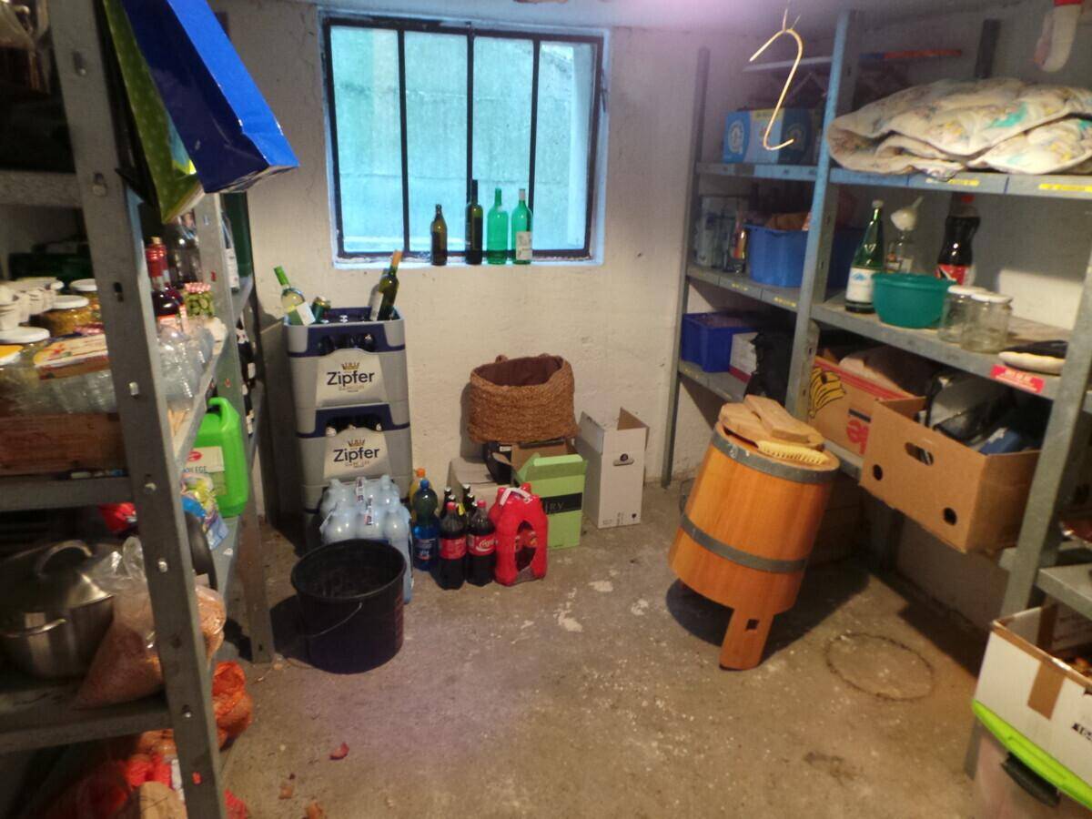 Kellerraum mit Regalen für Lagerung und einem kleinen Fenster, ideal für Vorräte und Abstellmöglichkeiten.