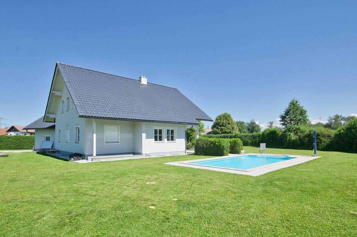 Ansicht des Hauses vom Garten aus mit großem Rasen und einem Swimmingpool.